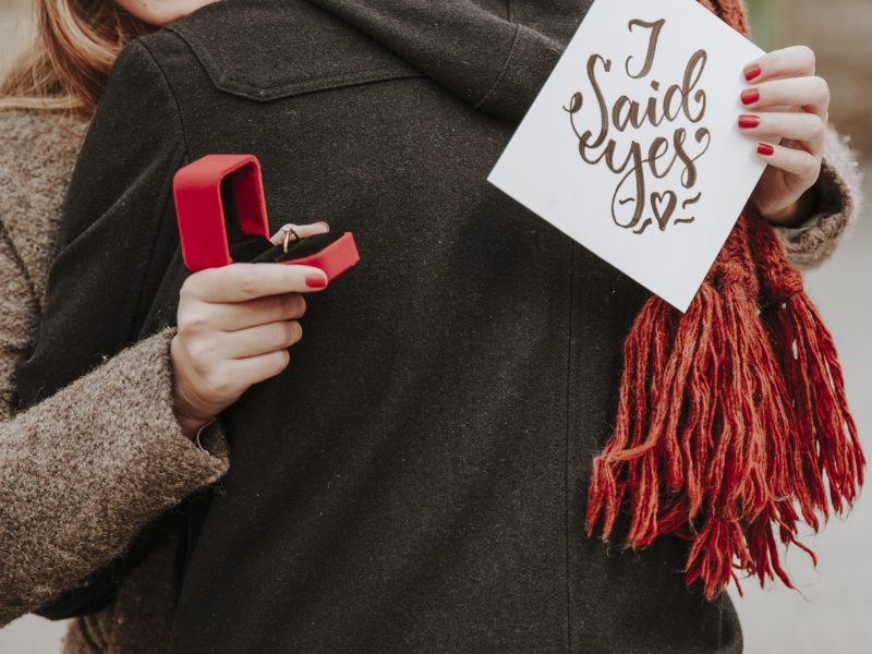 woman-with-ring-box-embracing-ban